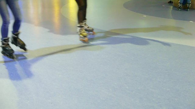 Teens, children on roller skates, roller skating, romantic active leisure in the entertainment center in the skating-rink 