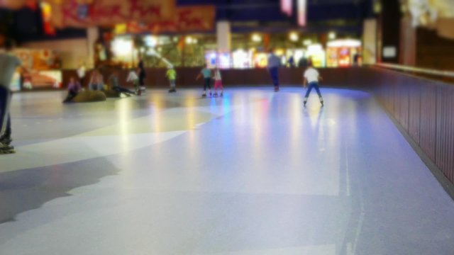Teens, children on roller skates, roller skating, romantic active leisure in the entertainment center in the skating-rink 