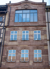 The facade of french building in modern style with windows and french balconies