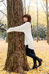 木の幹に抱きつきいている女性