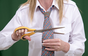 Woman using scissors to cut a necktie in half for a joke