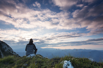 Man meditatidng over mountain and clouds