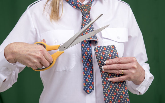 Woman Using Scissors To Cut A Necktie In Half For A Joke