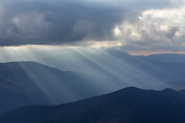 Beautiful dramatic sky with sun rays. over mountain..