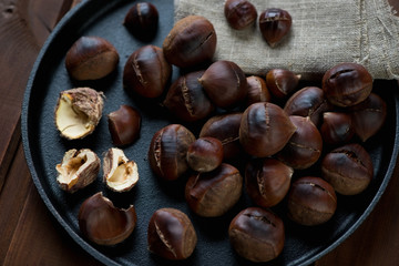 Roasted chestnuts in a frying pan, close-up, studio shot