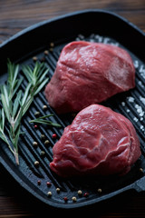 Closeup of two raw seasoned filet mignon beefsteaks, studio shot