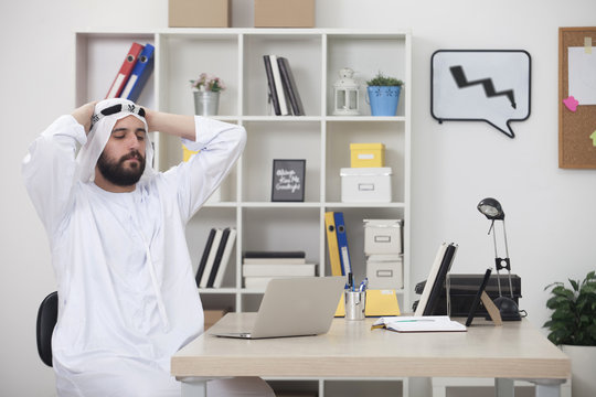 Young worried Arabic business man working on computer in his office