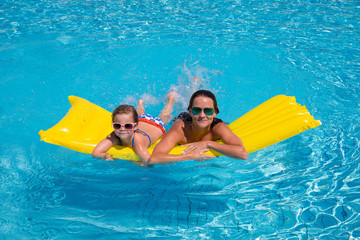 happy little girl and mother in pool