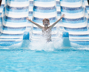 Boy going down water slide in pool - 102321971