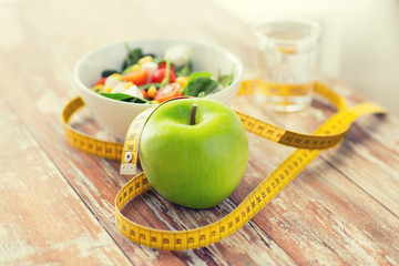 close up of green apple and measuring tape