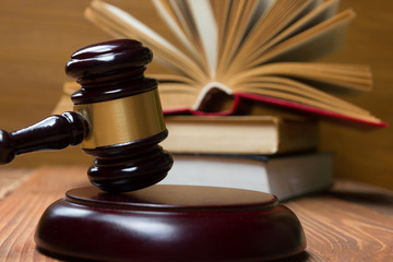 Obraz premium Law book with wooden judges gavel on table in a courtroom or law enforcement office.