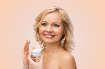 happy woman applying cream to her face