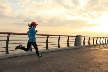Photo sur Aluminium Jogging young fitness woman runner running at sunrise seaside