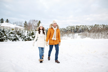 Fototapeta na wymiar happy couple walking along snowy winter field
