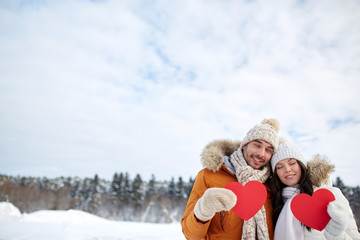 Obraz premium happy couple with red hearts over winter landscape