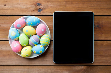 close up of easter eggs and blank tablet pc