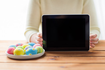 close up of woman with tablet pc and easter eggs