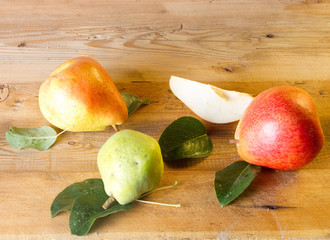 Whole and slice of ripe pears and green pear on a blackboard