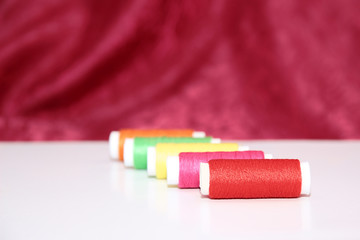Colorful thread spools over white background. Threads and pins on white background