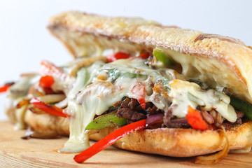Tasty beef steak sandwich with onions, mushroom and melted provolone cheese in a ciabatta