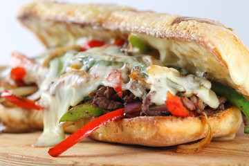 Fototapeta premium Tasty beef steak sandwich with onions, mushroom and melted provolone cheese in a ciabatta