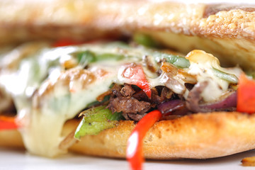 Tasty beef steak sandwich with onions, mushroom and melted provolone cheese in a ciabatta