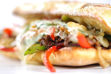 Tasty beef steak sandwich with onions, mushroom and melted provolone cheese in a ciabatta