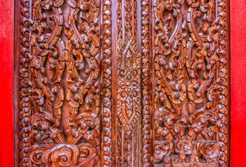 Thai wood carving art. The art on the door of Buddhist temple in Thailand.