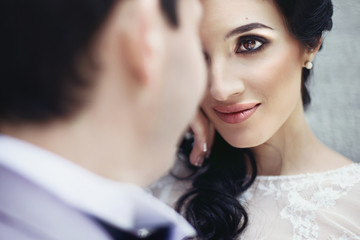 Gorgeous innocent brunette bride looking at handsome groom face