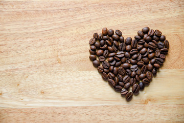 coffee beans in heart shape on wooden panel