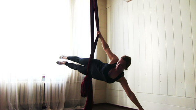 Young beauty woman is practicing aerial silk
