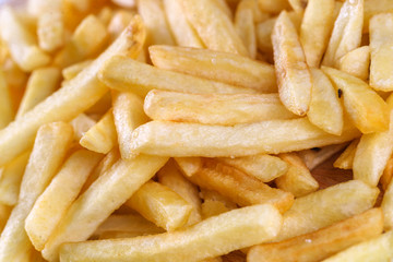 Tasty french fried potatoes on a wooden plate