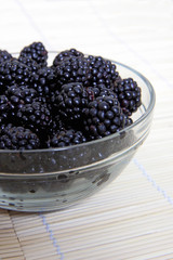 Glass bowl with ripe blackberries