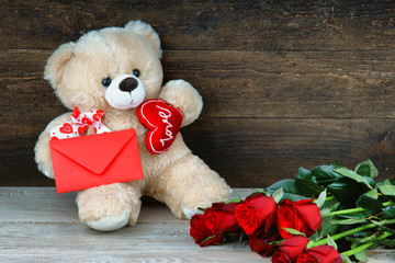 Teddy bear, red roses and red envelope