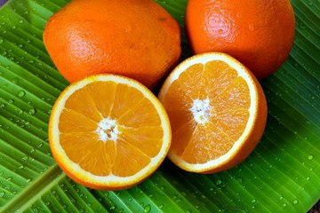 Fresh oranges on green banana leaf background