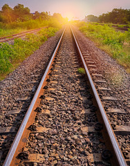 Fototapeta premium railway tracks in sun raise moment with flair of sun