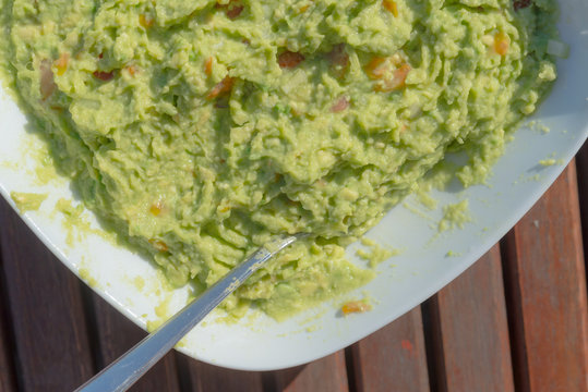Aerial view closeup of homemade spicy guacamole dip served in bo