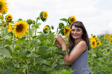 Beautiful girl smiling in the sunflowers