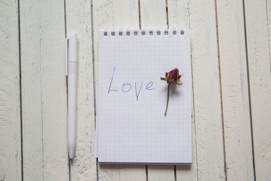 notebook with marker inscription I love you and rose on white