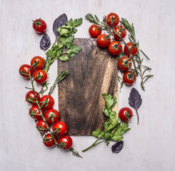 Vintage cutting board with herbs and vegetables on wooden rustic background top view close up place for text,frame