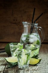 Refreshing drink with rosemary, lime and honey on the old wooden