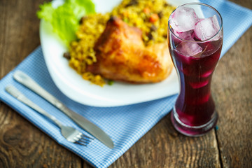 Dishes from chicken thigh with rice and lettuce and a glass of j