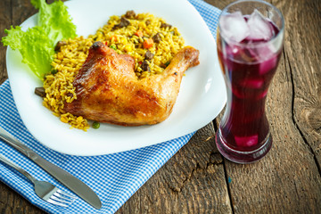 Dishes from chicken thigh with rice and lettuce and a glass of j
