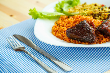 Tasty dish of roast beef with rice and salad leaves