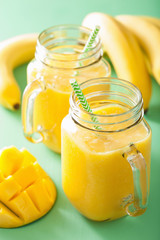 healthy mango pineapple smoothie in mason jars