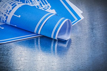 Blue blueprints on scratched metallic background construction co