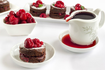 Round-shaped chocolate cake filled with raspberry sauce on white background.