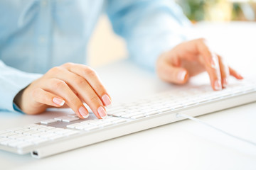 Woman office worker typing on the keyboard