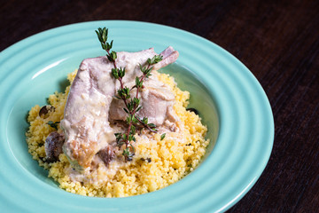 Stewed rabbit meat in creamy sauce with herbs and couscous.