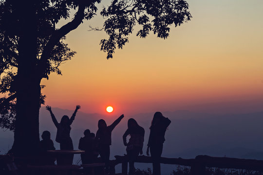 Happy peoples silhouetted with stunning sunset